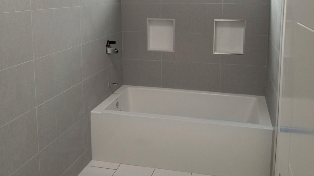 rectangular custom laid grey tiles for a bath tub and bathroom wall area